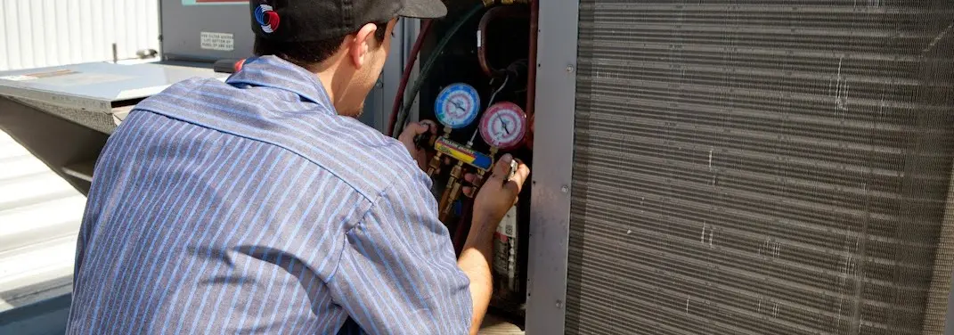HVAC technician servicing a condenser unit in Melissa