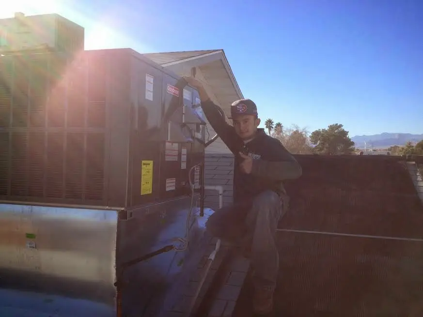HVAC technician performing Boiler Repair on a rooftop unit in Melissa